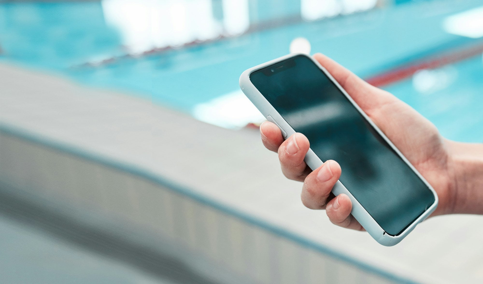 Person, hand and phone mockup by pool in social media, communication or networking in sports fitnes